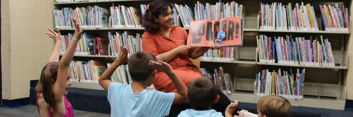 Ms. Karin reading a book to children