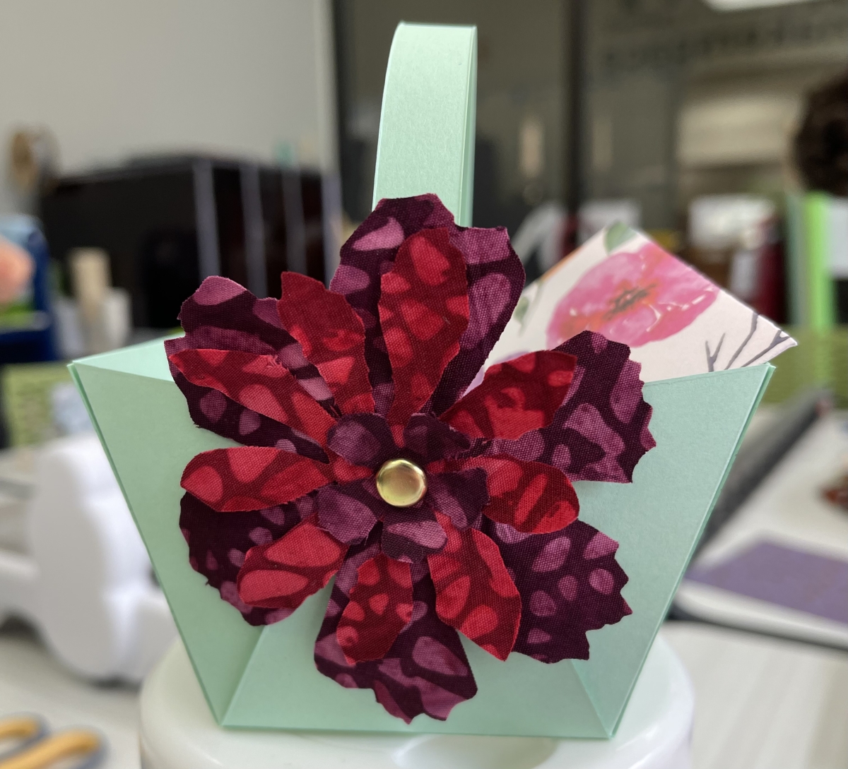 fabric flower adhered to paper basket