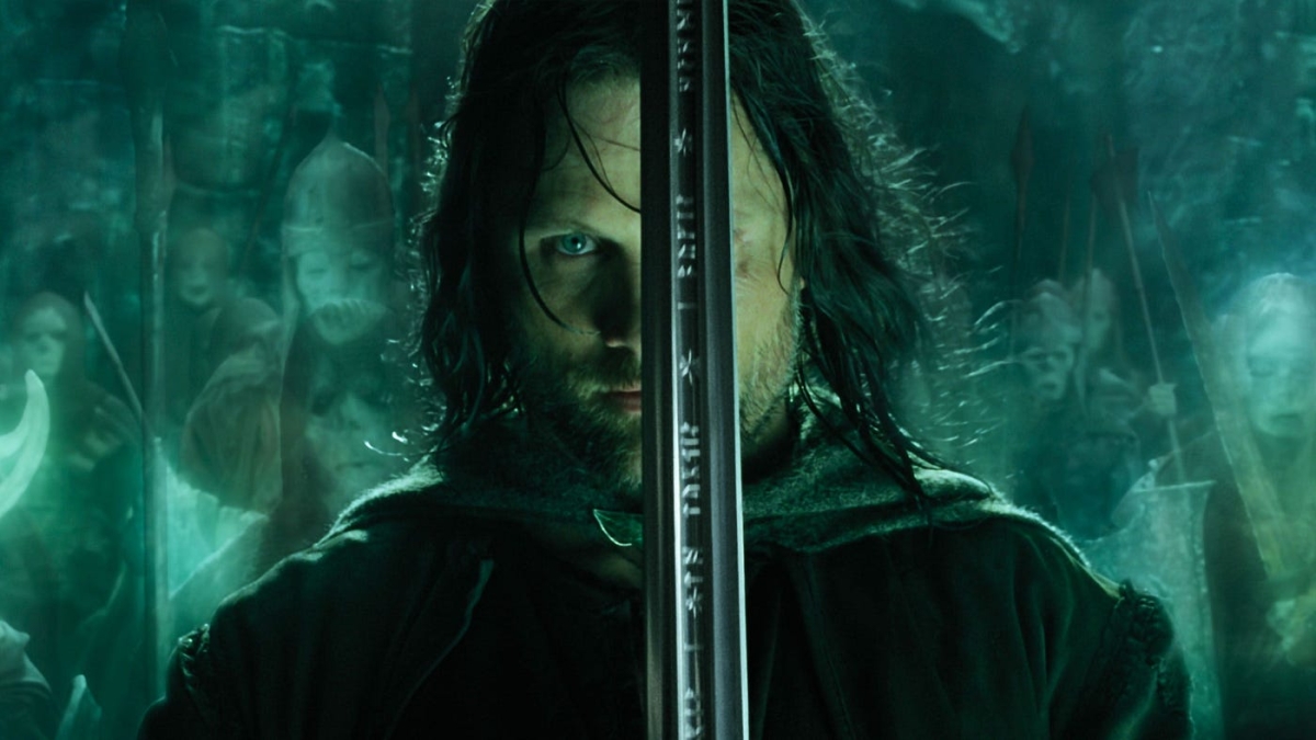 Aragorn holding up a sword covering his left eye, with ghost warriors in the background