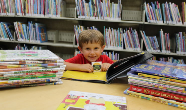 Child with 1000 books to read sticker and books